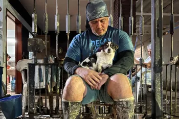 A man sitting with a dog in his lap